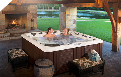 Enjoy some time spent on the patio next to a warm fireplace in your even warmer hot tub by Master Spas